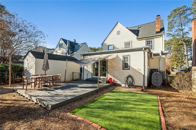 rear view of property with a lawn and a deck