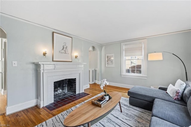 living room with a fireplace and dark wood-type flooring