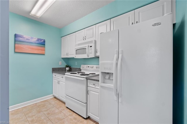 kitchen with white appliances, a textured ceiling, light tile patterned floors, and white cabinetry