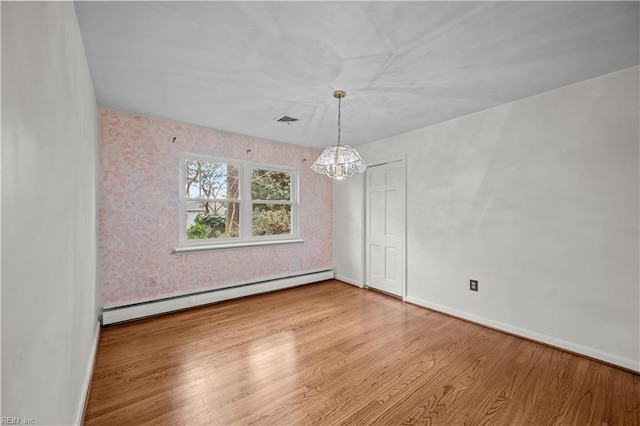 unfurnished dining area with baseboard heating, hardwood / wood-style flooring, and an inviting chandelier