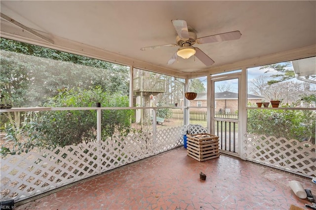 unfurnished sunroom featuring ceiling fan