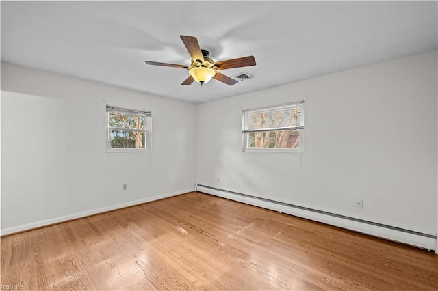 spare room with light hardwood / wood-style floors, a baseboard heating unit, and ceiling fan