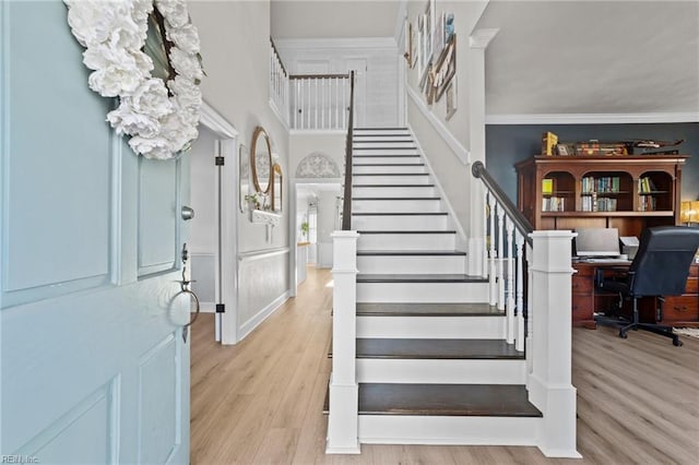 entryway featuring light wood-type flooring and ornamental molding