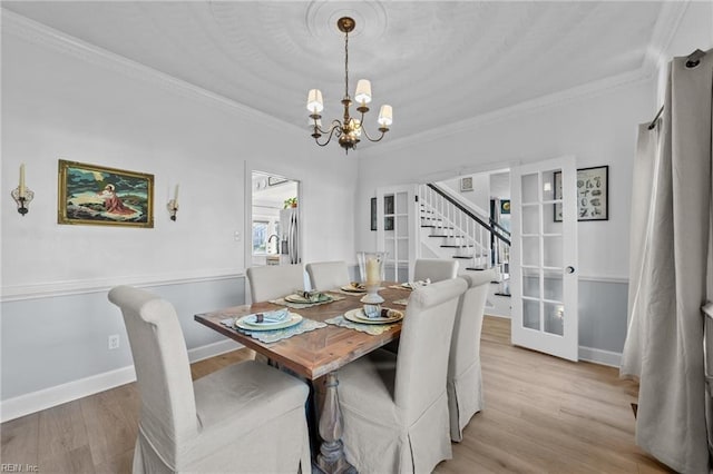 dining area featuring a chandelier, light wood-type flooring, and ornamental molding