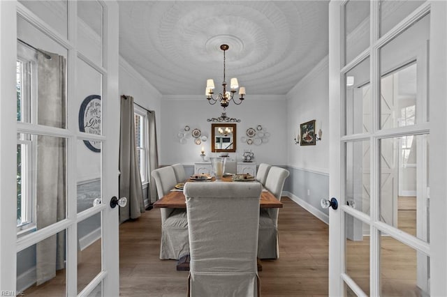 dining room featuring french doors, a chandelier, hardwood / wood-style floors, and crown molding