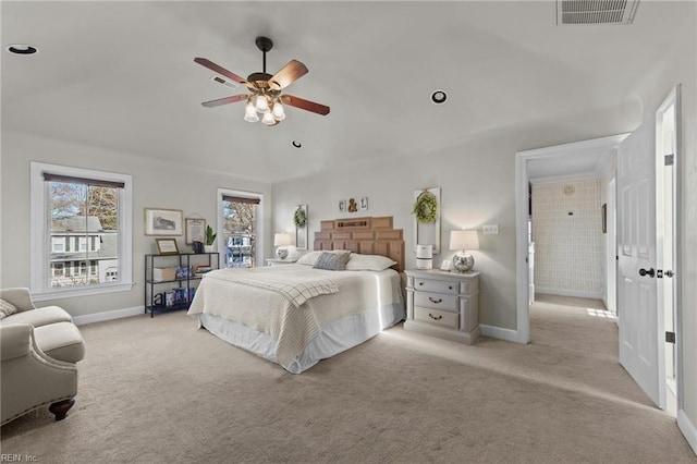 bedroom featuring ceiling fan, light colored carpet, and multiple windows