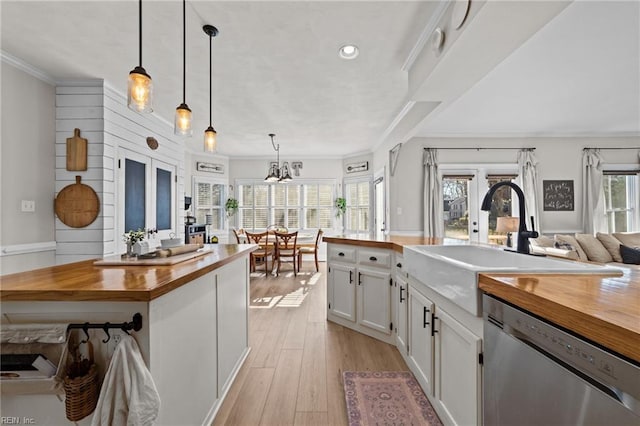 kitchen featuring hanging light fixtures, wood counters, french doors, white cabinets, and stainless steel dishwasher