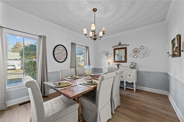 dining room with an inviting chandelier, crown molding, and wood-type flooring