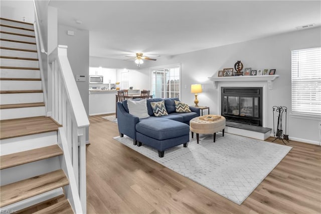 living room with ceiling fan and light wood-type flooring