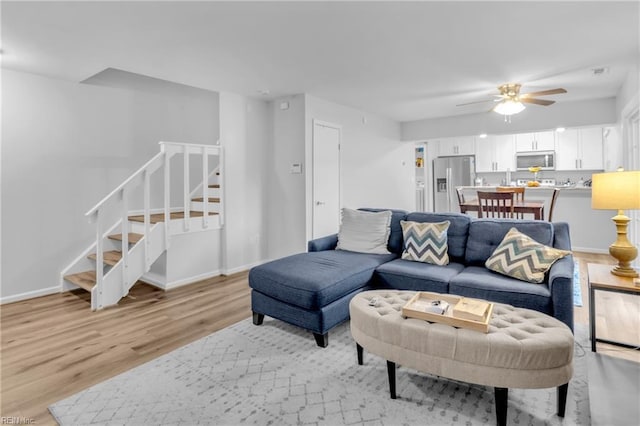 living room with ceiling fan and light hardwood / wood-style flooring