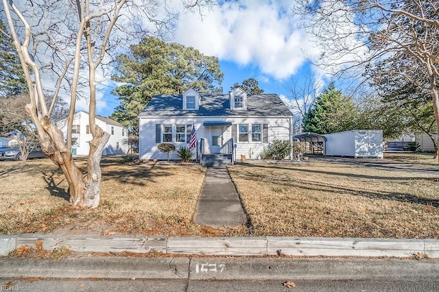 cape cod house featuring a front yard and a carport