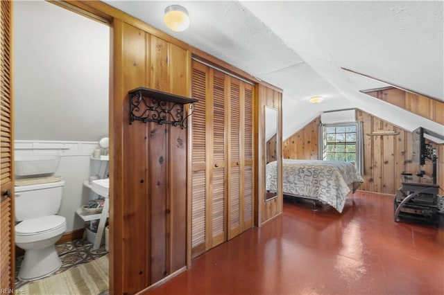 bedroom featuring a closet, wood walls, and vaulted ceiling