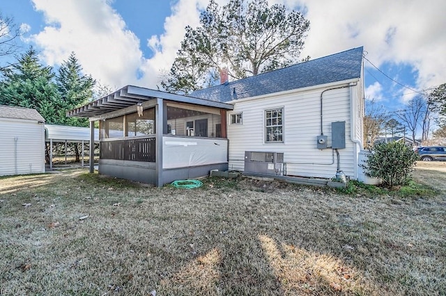 back of property featuring a yard and a sunroom