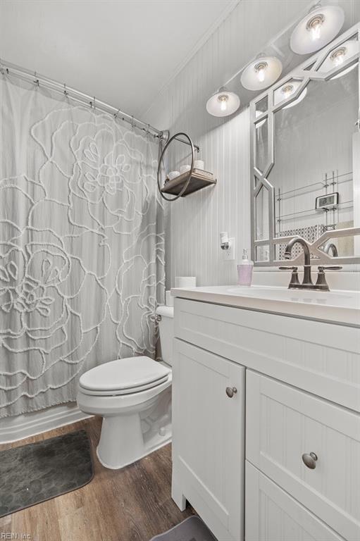 bathroom with toilet, vanity, and hardwood / wood-style floors