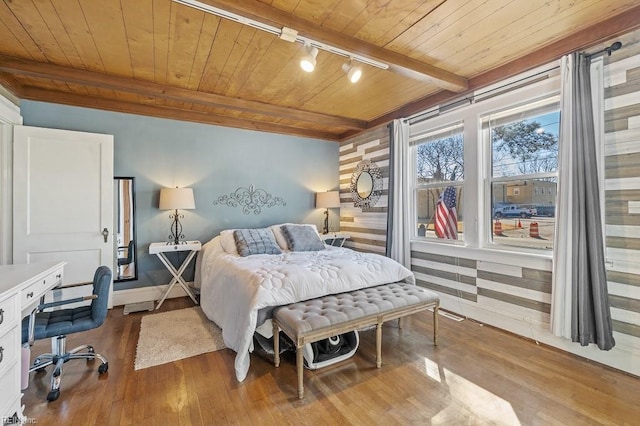 bedroom featuring beamed ceiling, hardwood / wood-style flooring, track lighting, and wooden ceiling