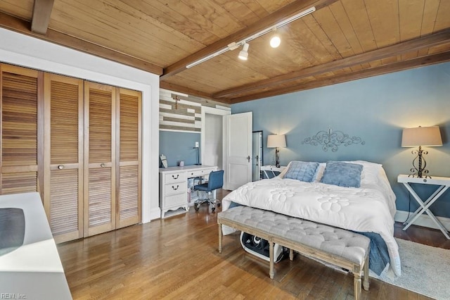 bedroom with rail lighting, a closet, wood-type flooring, and wooden ceiling