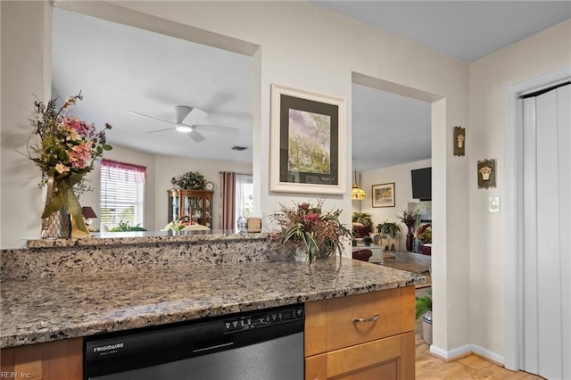 kitchen featuring light stone counters, light wood-type flooring, ceiling fan, and dishwasher