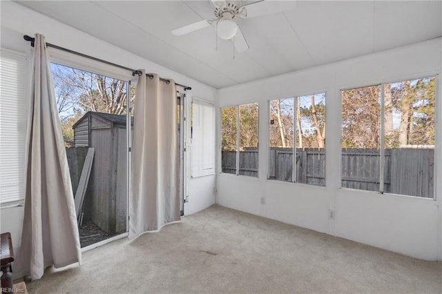 unfurnished sunroom with ceiling fan