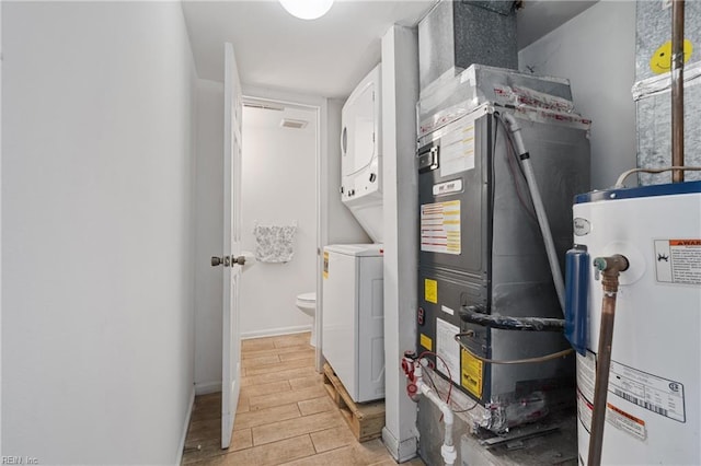 utility room featuring stacked washer / dryer, heating unit, and water heater