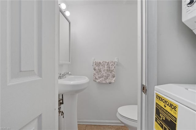 bathroom featuring a sink, baseboards, and toilet