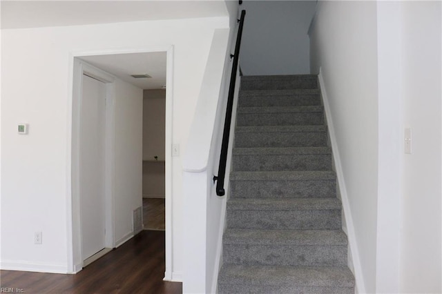 stairway with baseboards and wood finished floors