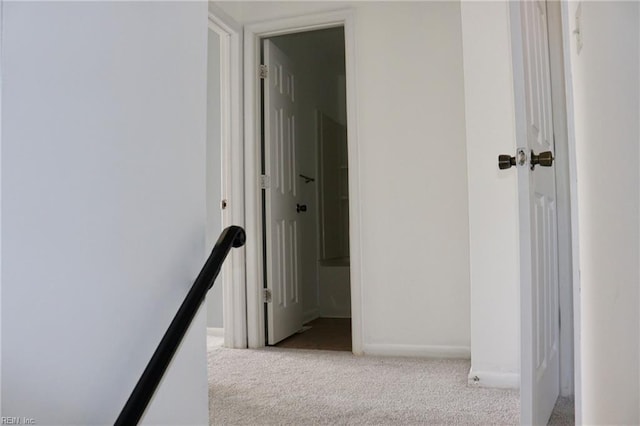 corridor featuring baseboards and carpet flooring