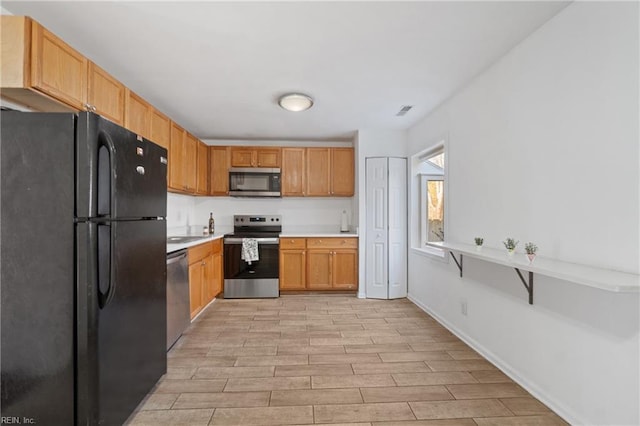 kitchen featuring visible vents, baseboards, wood tiled floor, light countertops, and stainless steel appliances