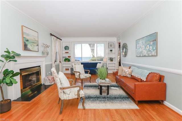 living room with crown molding, built in shelves, and wood-type flooring