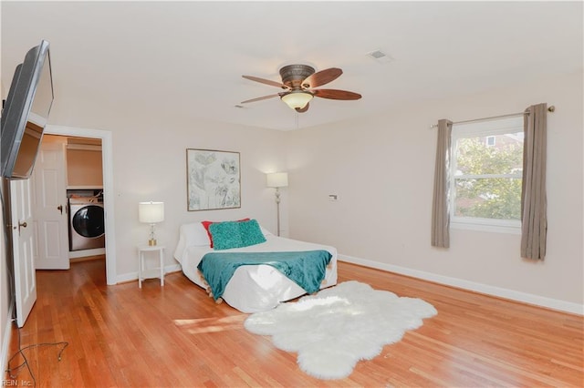 bedroom featuring washer / dryer, ceiling fan, and light hardwood / wood-style floors