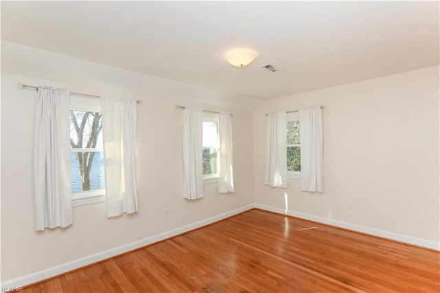 spare room featuring hardwood / wood-style flooring and a wealth of natural light