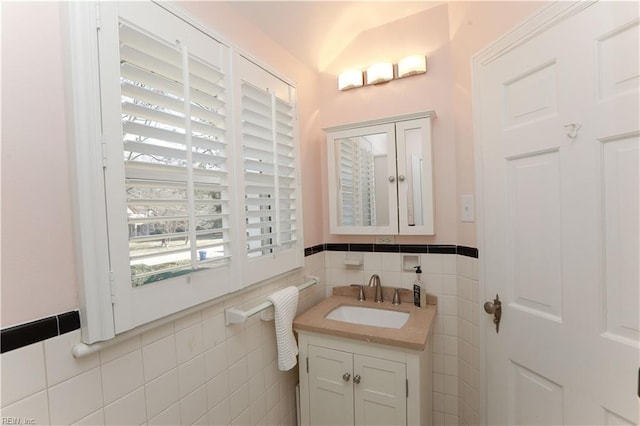 bathroom featuring tile walls, vaulted ceiling, and vanity