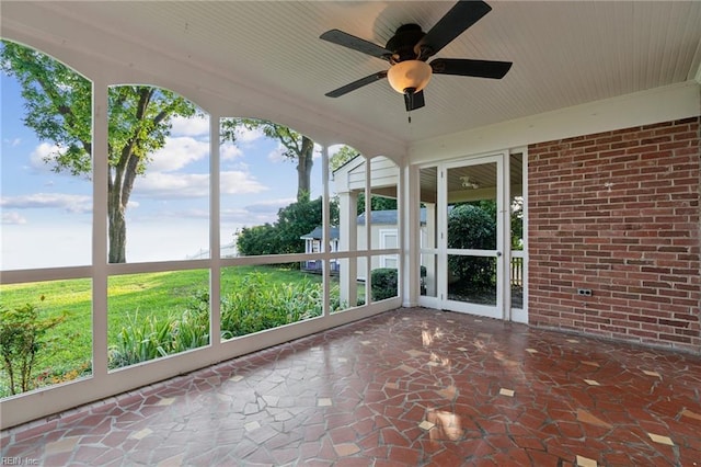 unfurnished sunroom with ceiling fan