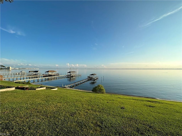 dock area with a yard and a water view