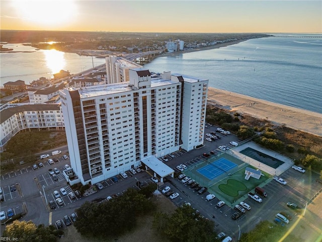 aerial view at dusk with a beach view and a water view