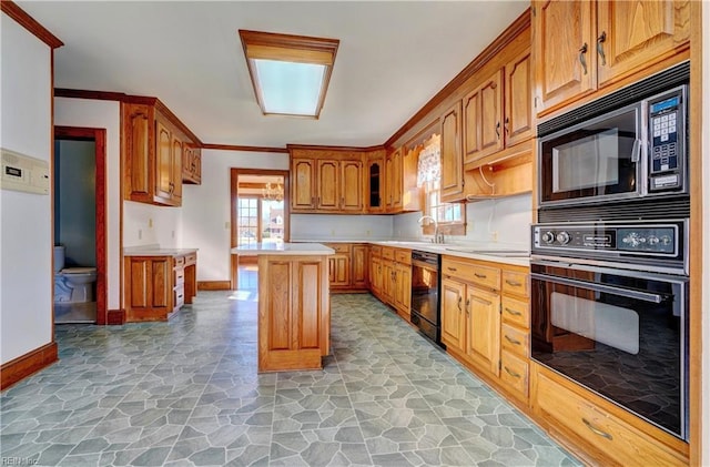 kitchen with black appliances, sink, crown molding, and a kitchen island