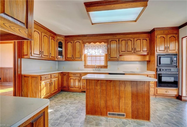 kitchen featuring a kitchen island, black appliances, and sink