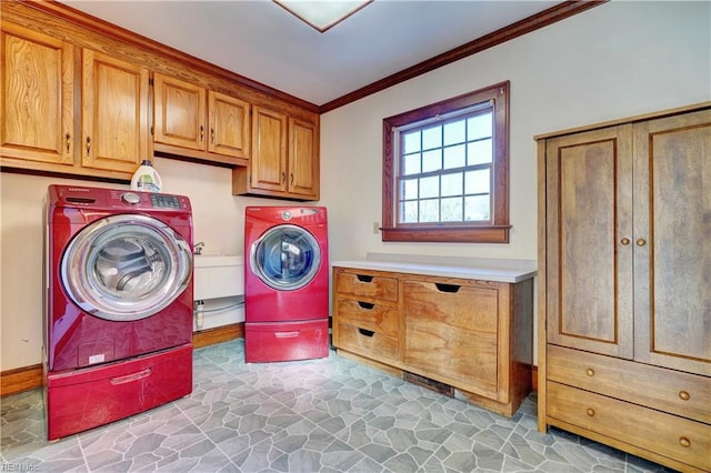 laundry area featuring washer and dryer, crown molding, and cabinets