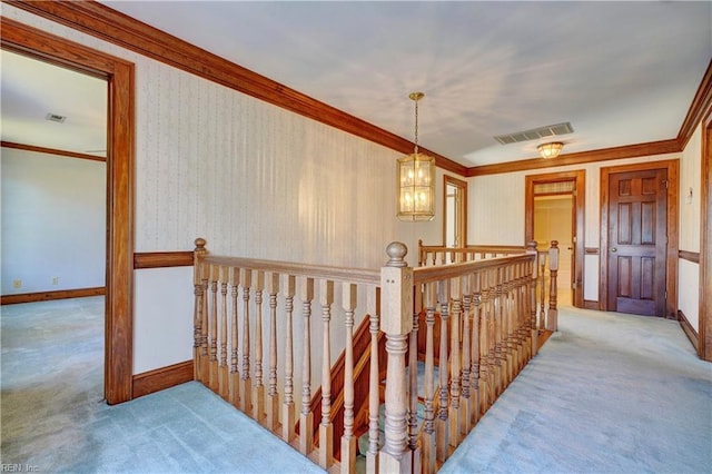 hallway featuring a chandelier, carpet, and crown molding