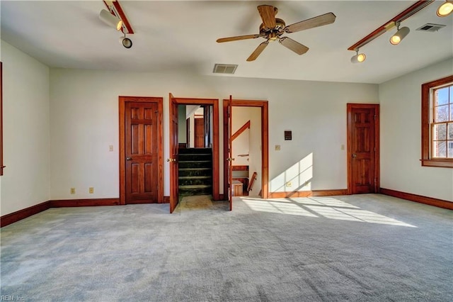 unfurnished bedroom with ceiling fan, light carpet, and rail lighting