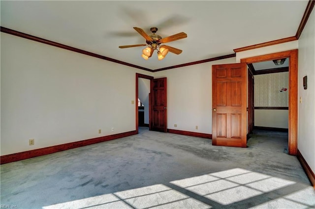 carpeted spare room featuring ceiling fan and crown molding