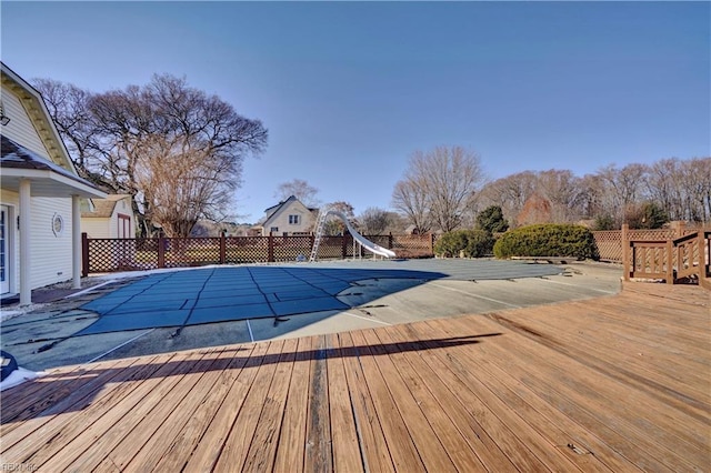 view of pool with a water slide and a deck