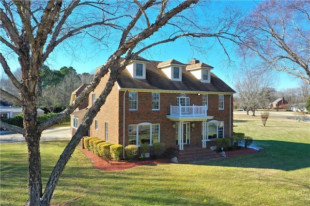 view of front of home with a balcony and a front yard