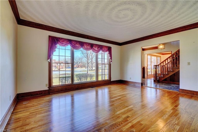 unfurnished living room featuring a notable chandelier, light hardwood / wood-style flooring, and ornamental molding