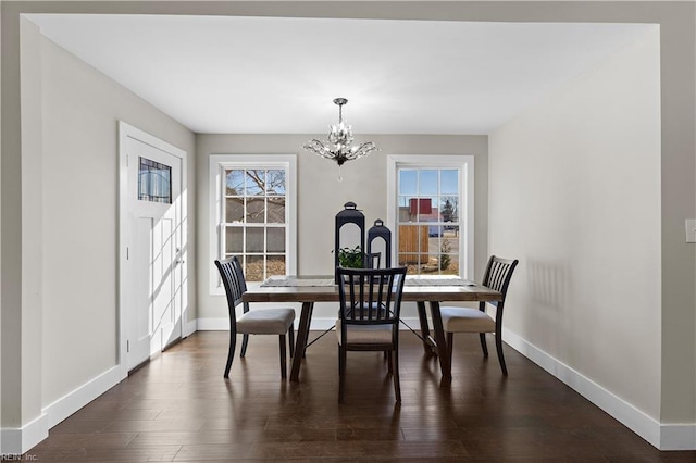 dining area with dark wood-type flooring and a notable chandelier