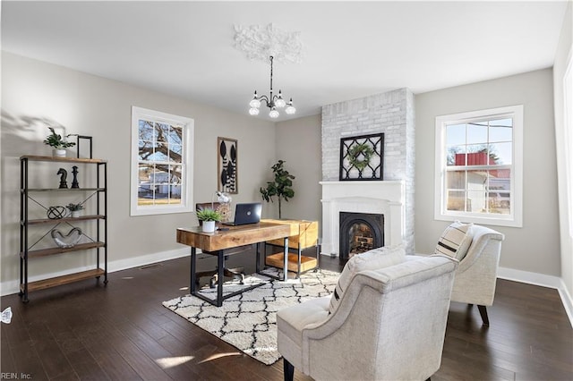 office featuring a chandelier, a large fireplace, and dark wood-type flooring