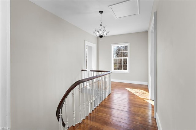 stairs with wood-type flooring and a chandelier