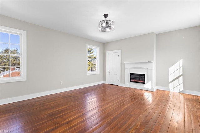 unfurnished living room featuring hardwood / wood-style flooring and a notable chandelier