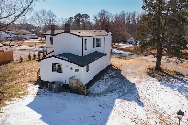 snow covered house featuring central air condition unit