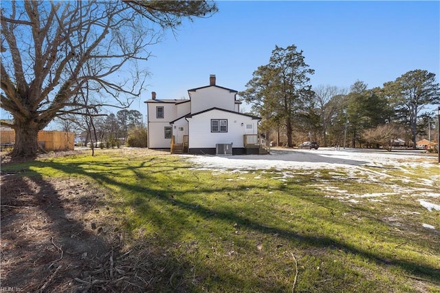 rear view of house featuring a yard and central air condition unit