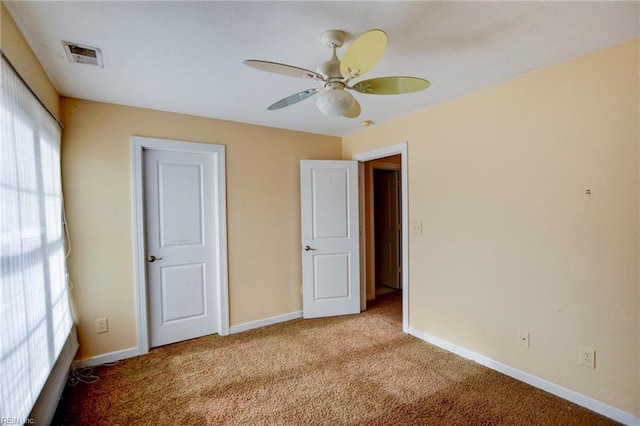 unfurnished bedroom featuring ceiling fan and light carpet